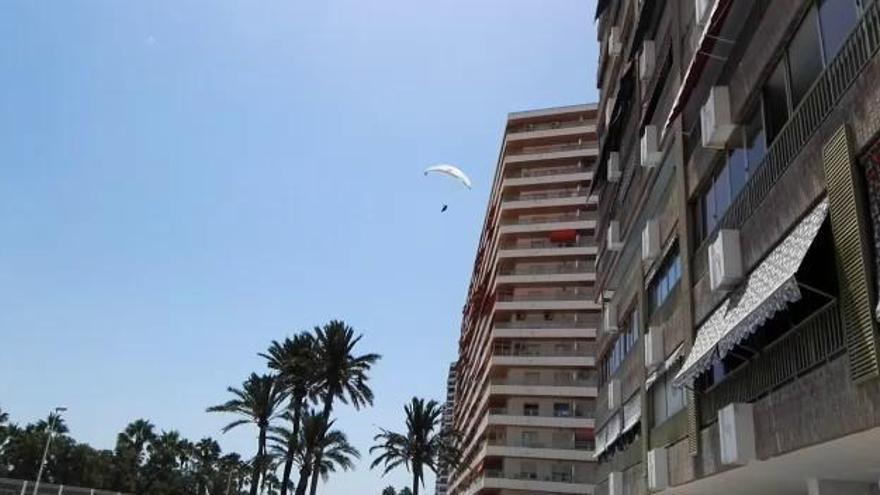 Un parapente aterriza en la playa de Cullera abarrotada