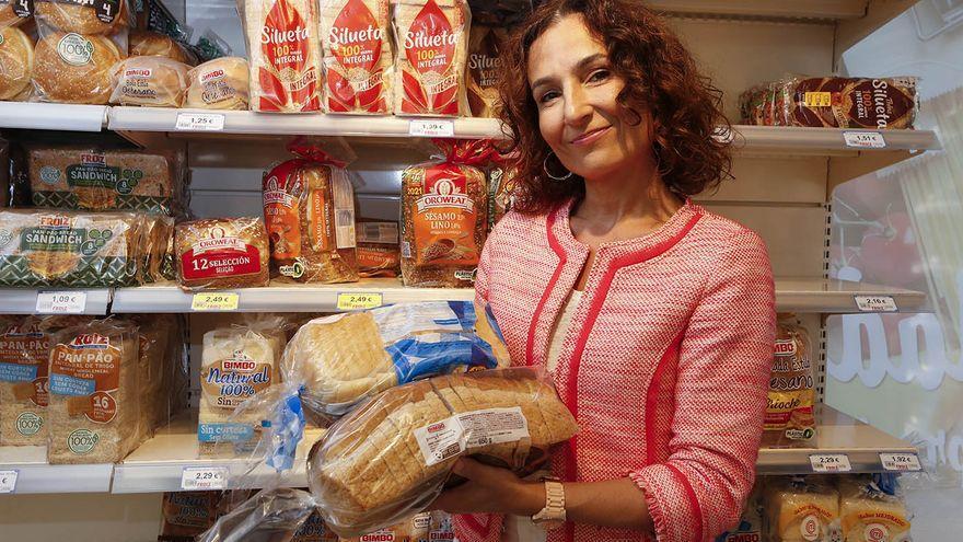 Bertina Ferrández muestra dos panes de molde en un supermercado.