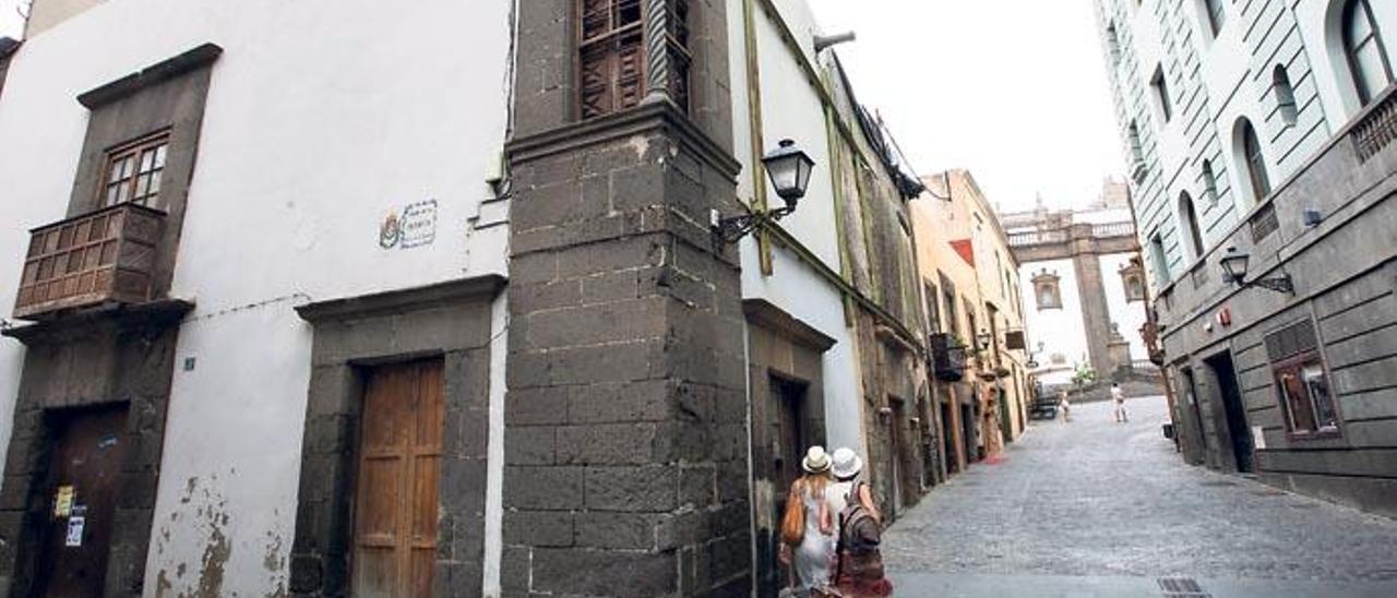 Dos turistas pasan ante la Casa del Deán, del siglo XVI, en la esquina de la calle Pelota con Herrería en Vegueta.