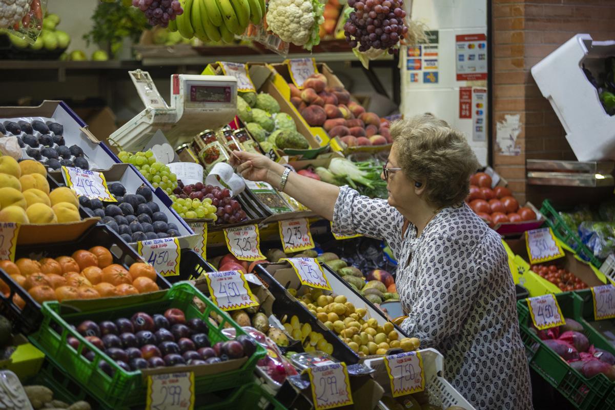 Archivo - Una mujer compra en uno de los puestos del mercado de abastos de Triana. A 13 de septiembre de 2022, en Sevilla (Andalucía, España).