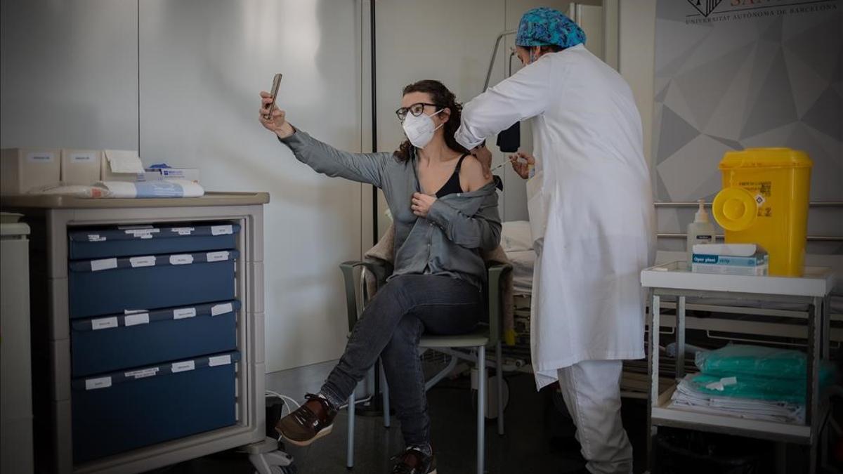 Una enfermera vacuna a una profesional sanitaria con la vacuna de Pfizer-BioNtech contra el COVID-19 en el Hospital de la Santa Creu i Sant Pau de Barcelona