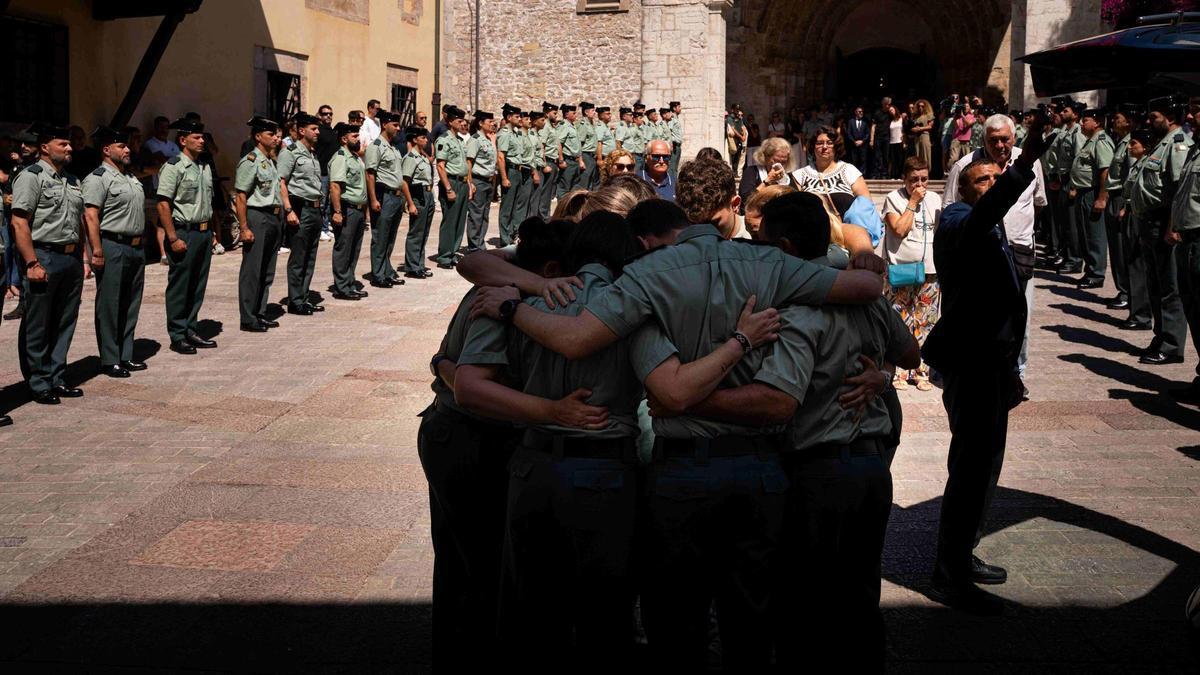 Un grupo de agentes de la Guardia Civil se abrazan, desconsolados, antes del funeral por Laura Cruz, en Llanes.