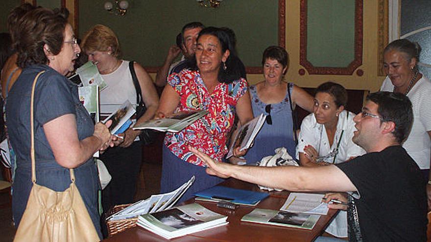 Cándido Ruiz, a la derecha, conversa con algunos socios de Proculto mientras se distribuye la revista.