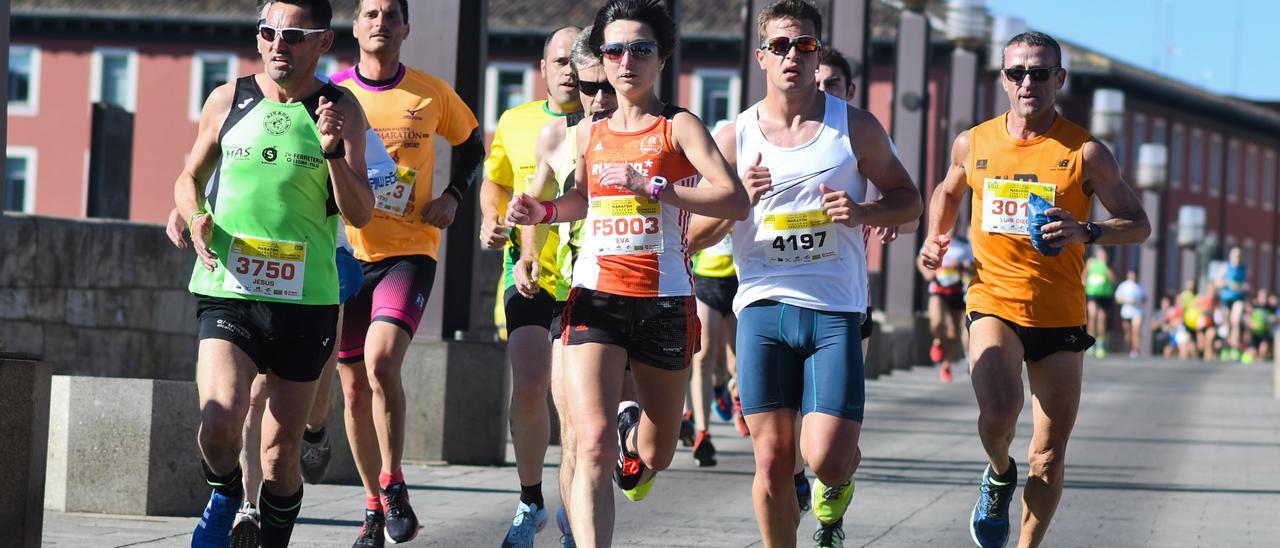 Varios participantes, a su paso por el puente de Piedra en una edición de la carrera.