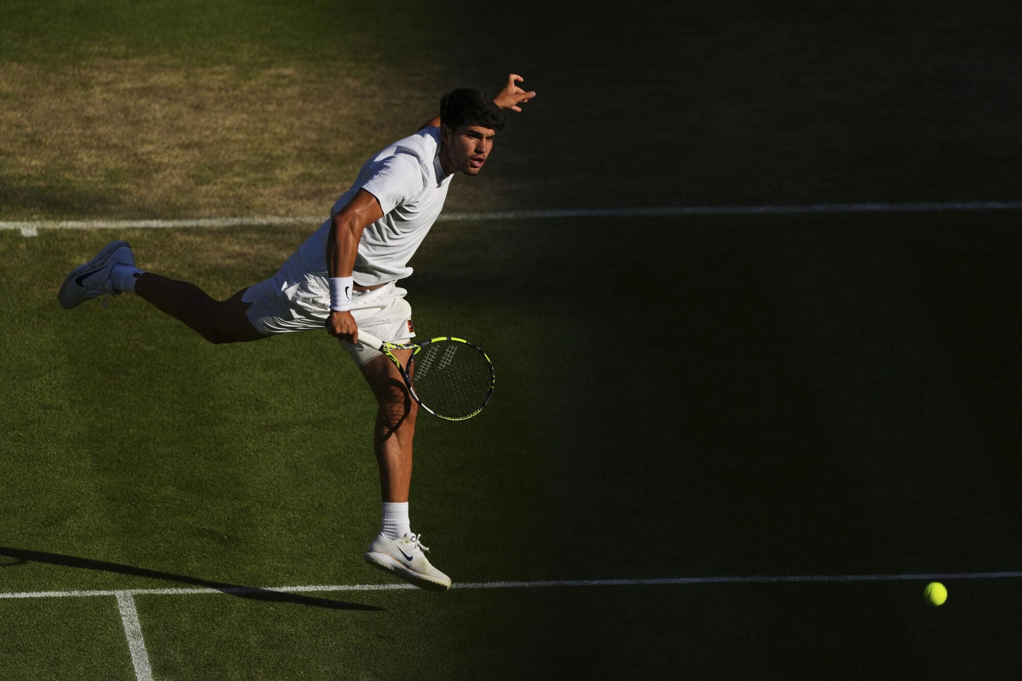 Spain's Carlos Alcaraz returns to Britain's Cameron Norrie during a quarterfinal men's singles match at the Wimbledon Tennis Championships in London, Tuesday, July 8, 2025. (AP Photo/Joanna Chan)