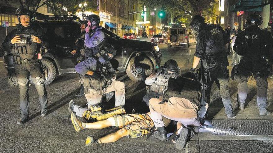 El cuerpo del fallecido por disparos en Portland, en el suelo rodeado de policías.