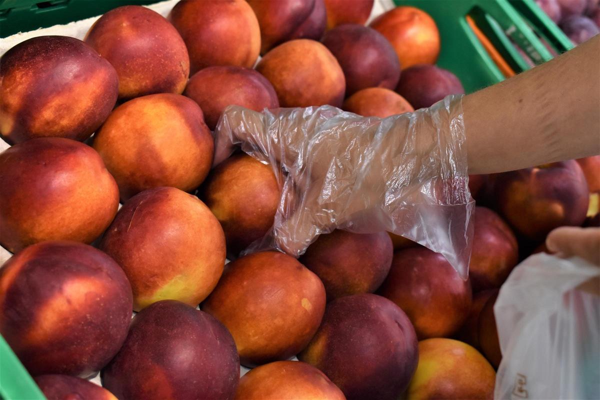 Un cliente durante la selección de fruta en el lineal de Mercadona.
