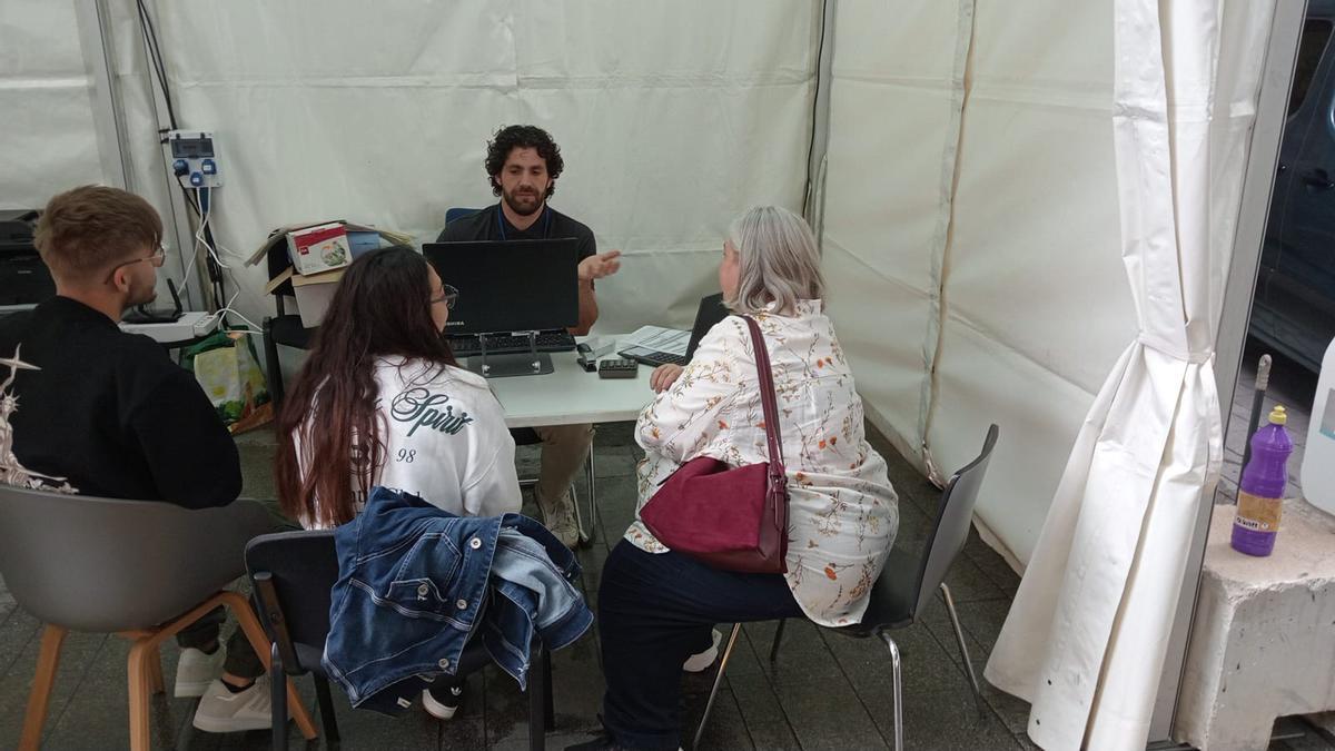 Un vendedor y tres clientes en una de las carpas de la Fira del Motor de Gandia