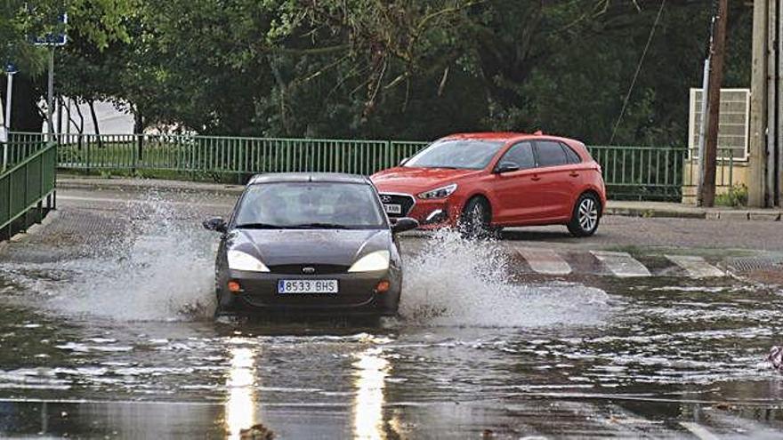 Dos vehículos avanzan por encima de una de las balsas de agua provocadas por la tormenta en Zamora capital.