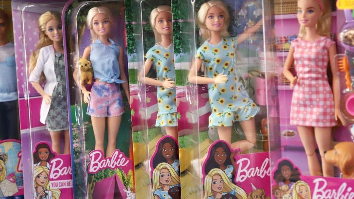 Barbies de varias profesiones en la estantería de una juguetería.