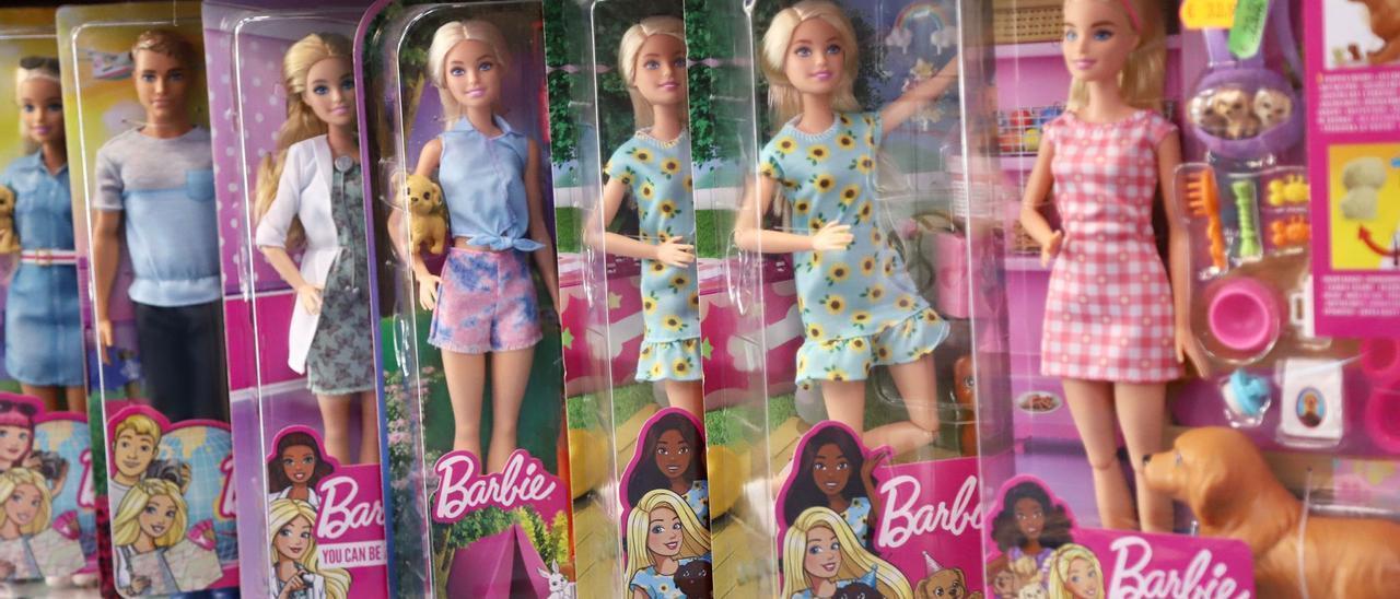 Barbies de varias profesiones en la estantería de una juguetería.