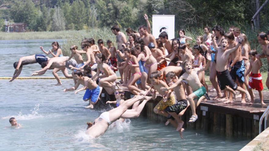 Moment en què la mainada participant es llança a l&#039;aigua des de la plataforma de la zona de bany.