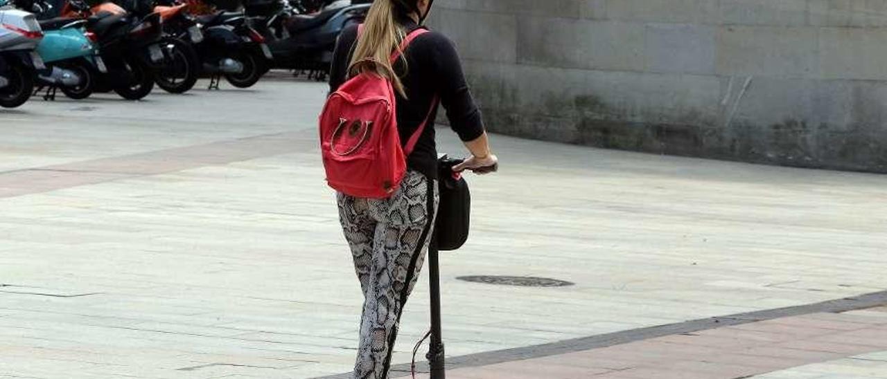 Una mujer circulando en patinete eléctrico.