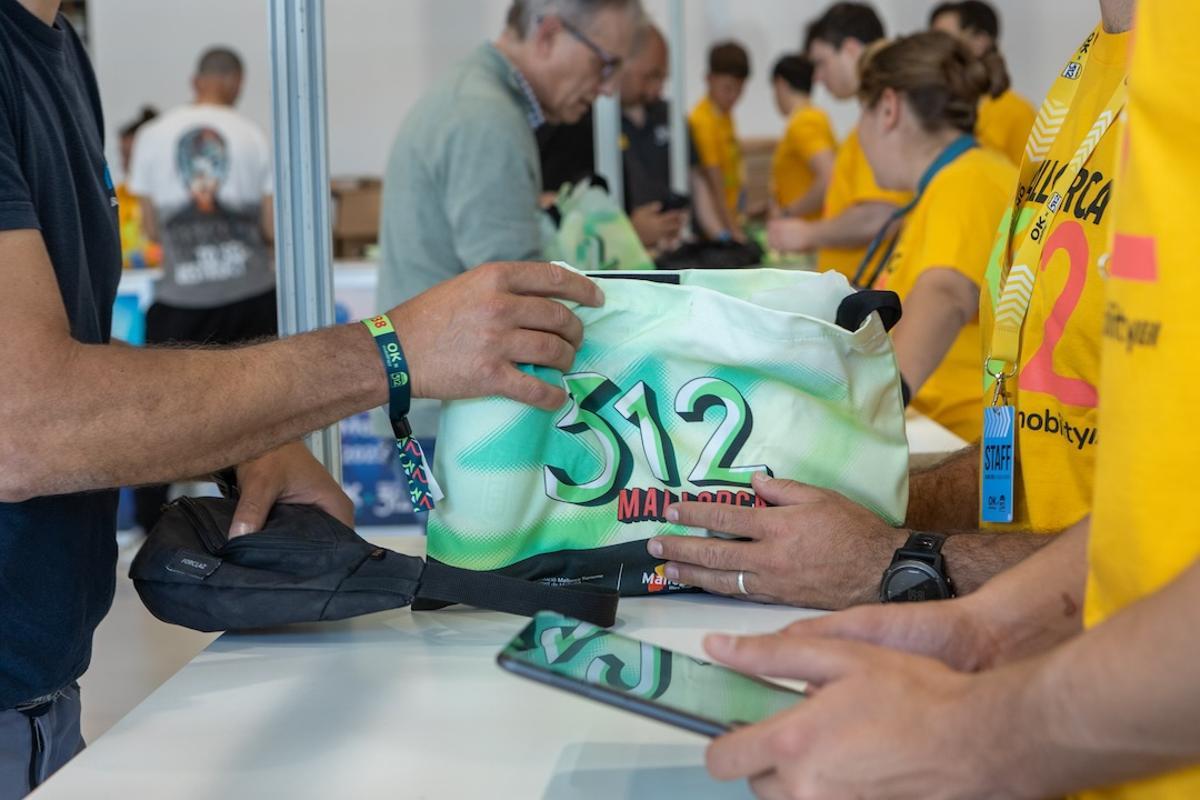La organización entrega a un participante el 'pack' de la prueba.