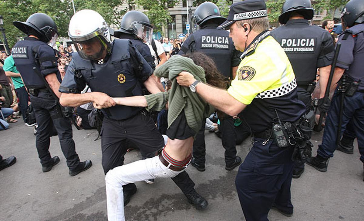 Diversos agents subjecten un manifestant a la plaça de Catalunya.