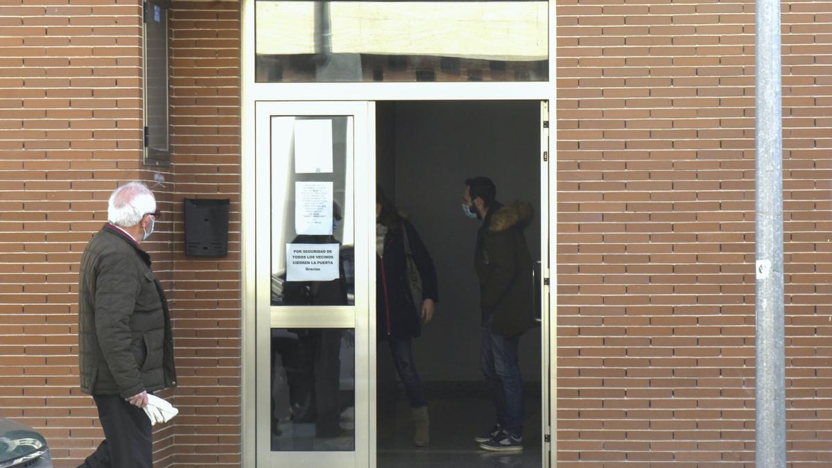 Un hombre pasa frente al portal donde se ha localizado el cadáver de una mujer.