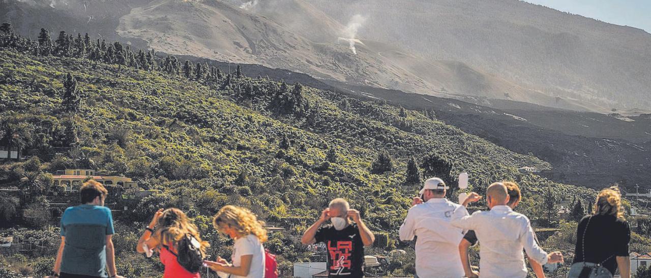Un grupo de turistas observa el volcán Tajogaite.