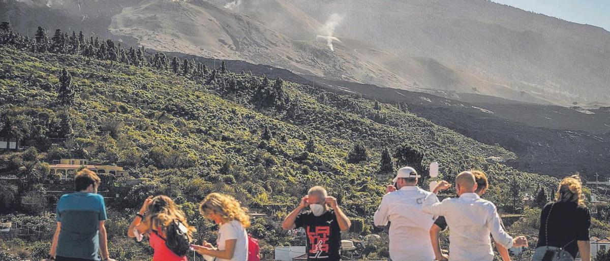 Un grupo de turistas observa el volcán Tajogaite.