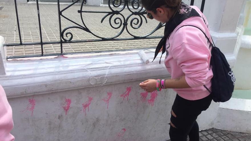 Una joven limpia unas pintadas en la PlaÃ§a Major de sa Pobla.