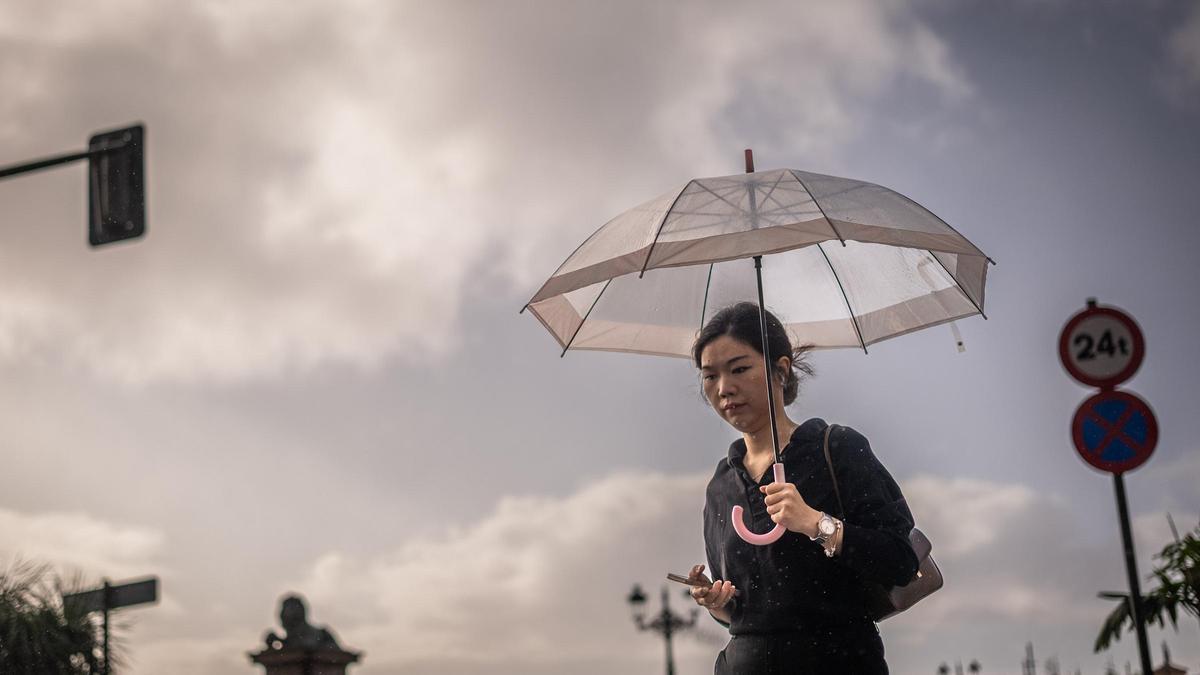 Una joven pasea bajo la lluvia en Tenerife.