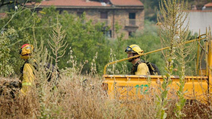 Dos bomberos trabajan en el incendio en Casas de Miravete