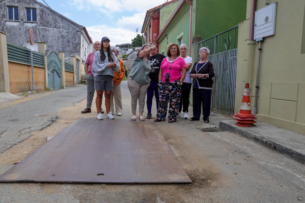 Los vecinos, concentrados junto a la plancha metálica que tapa el socavón.