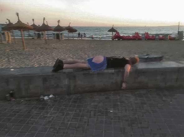 6 Un turista ebrio yace dormido en el muro de la playa.