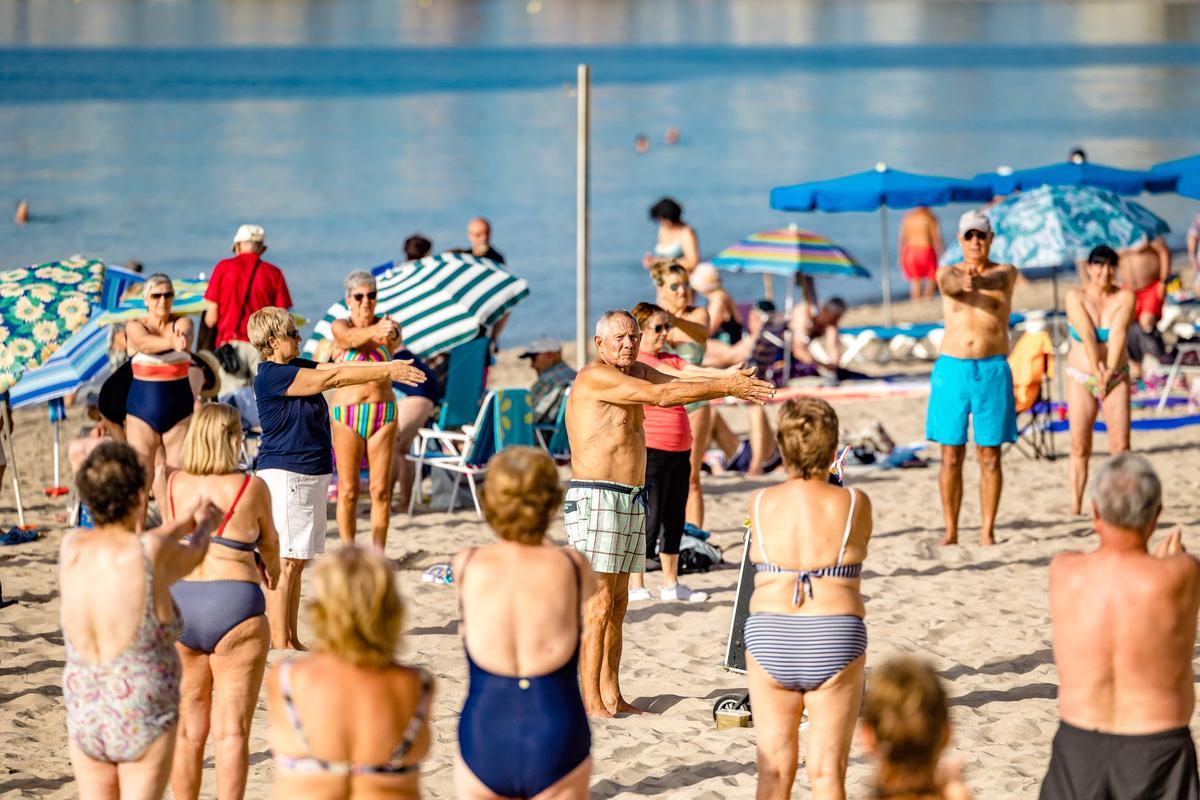 Un grupo de jubilados realiza ejercicio en la playa, en Benidorm.