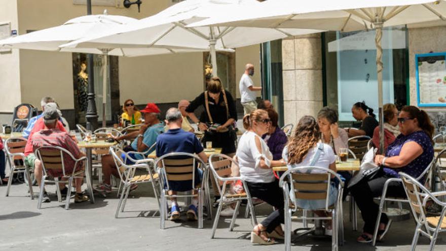 Una camarera atiende mesas en una terraza de la capital grancanaria.