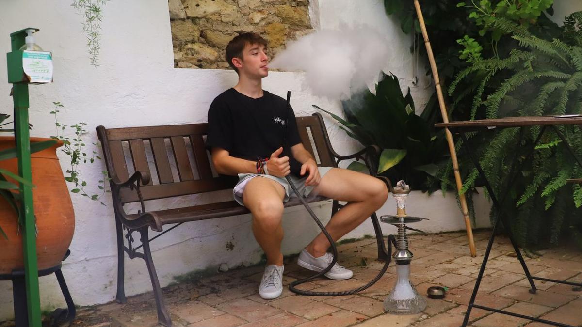 Un joven fumando cachimba en uno de los patios.