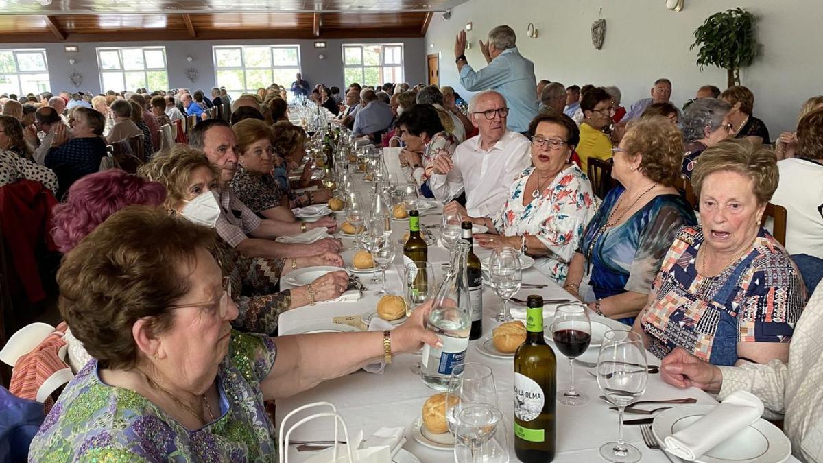 Sobre estas líneas, un momento de la misa en la iglesia de Posada. Arriba, asistentes a la comida de hermandad celebrada en Pruvia. | J. A. O.