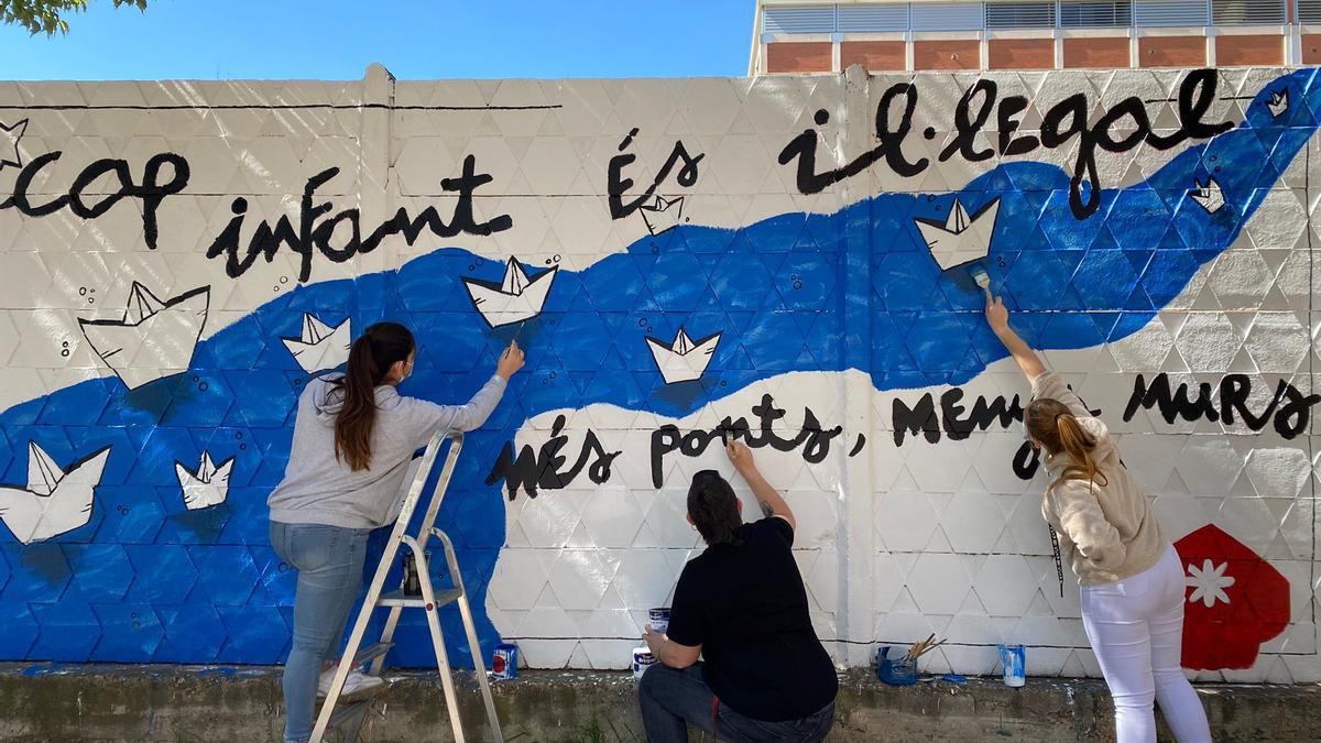 Unos niños pintan un mural contra el racismo en una actividad organizada por Fundesplai, este sábado.