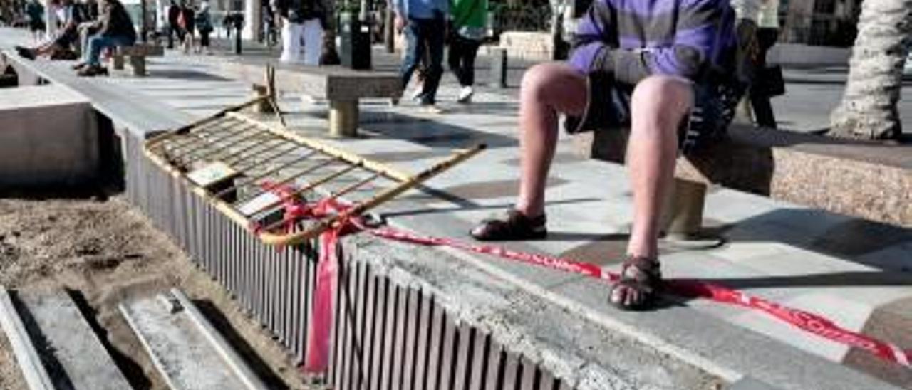 Un turista observa dos de las piezas tiradas en la arena.