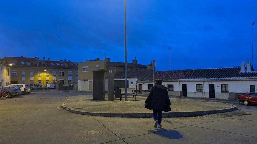 Una joven camina hacia el centro de la plaza de Bermillo de Sayago.  | ALBA PRIETO