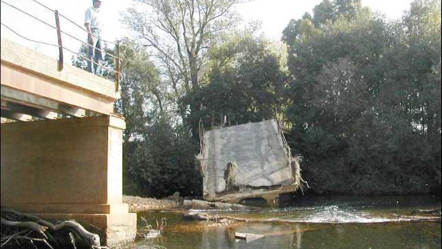 Un hombre observa el material acumulado en el lecho del río Eria procedente del viejo puente