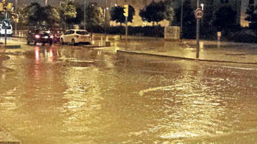 Un coche atrapado en el agua en el Paseo Marítimo.