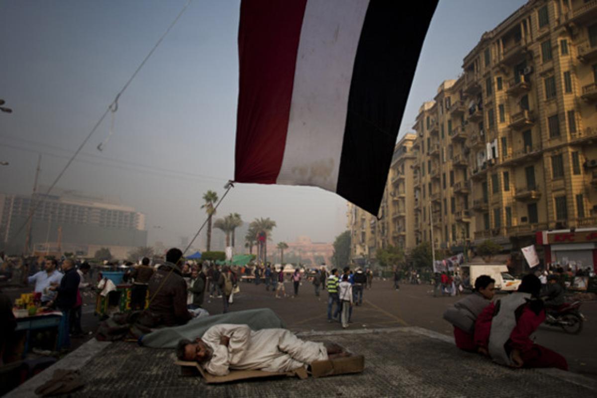 Un manifestant dorm a sota d’una bandera egípcia a la plaça Tahrir, al Caire.