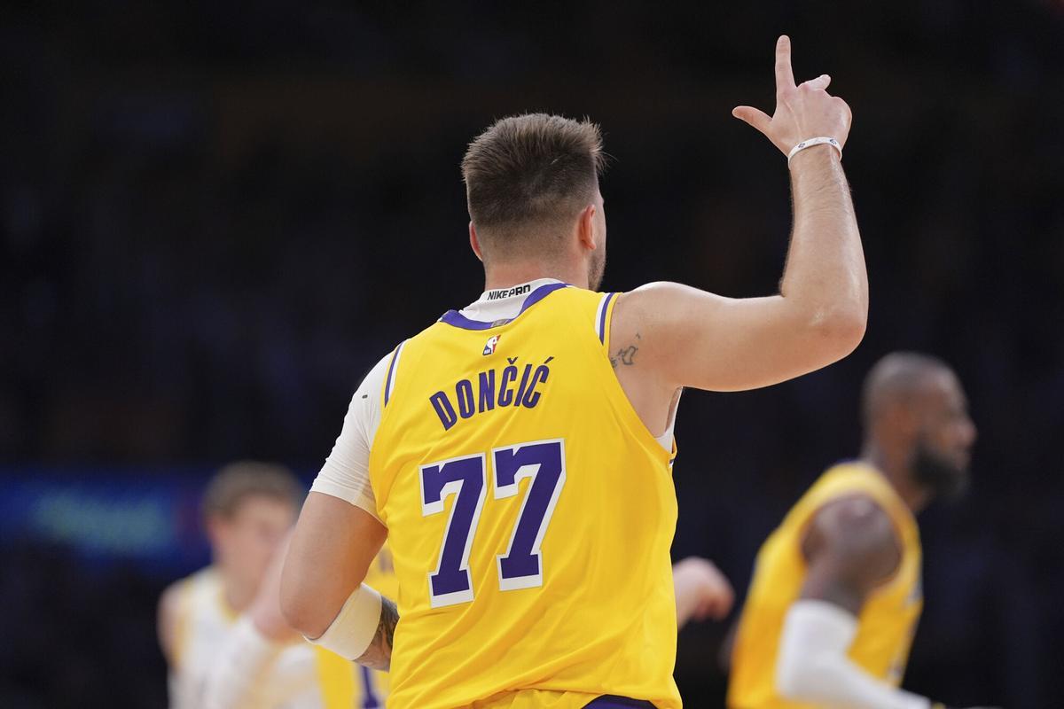 Los Angeles Lakers guard Luka Doncic celebrates after making his first basket as a Laker, a three-point shot, during the first half of an NBA basketball game against the Utah Jazz, Monday, Feb. 10, 2025, in Los Angeles. (AP Photo/Mark J. Terrill)