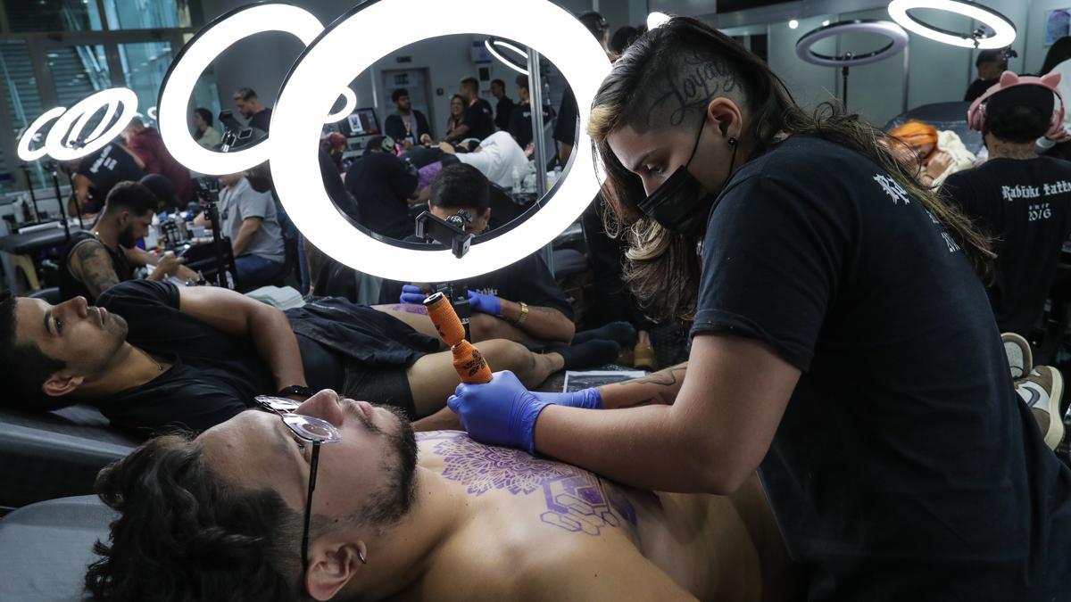 Un tatuador realiza un tatuaje en un festival de esta disciplina en Río de Janeiro