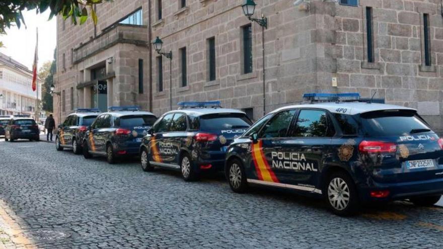En la imagen, varios coches de la Policía Nacional aparcados ante la Comisaría de Santiago