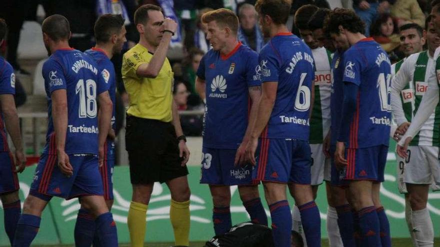 Los jugadores del Oviedo conversan con el árbitro, con Alfonso tendido en el suelo, en el partido de Córdoba.