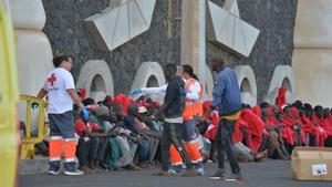 Trabajadores de la Cruz Roja al lado de los migrantes que han llegado en un cayuco al puerto de La Restinga, a 23 de octubre de 2023, en El Hierro, Santa Cruz de Tenerife, Tenerife, Canarias (España). La embarcación de Salvamento Marítimo, Salvamar Adhara