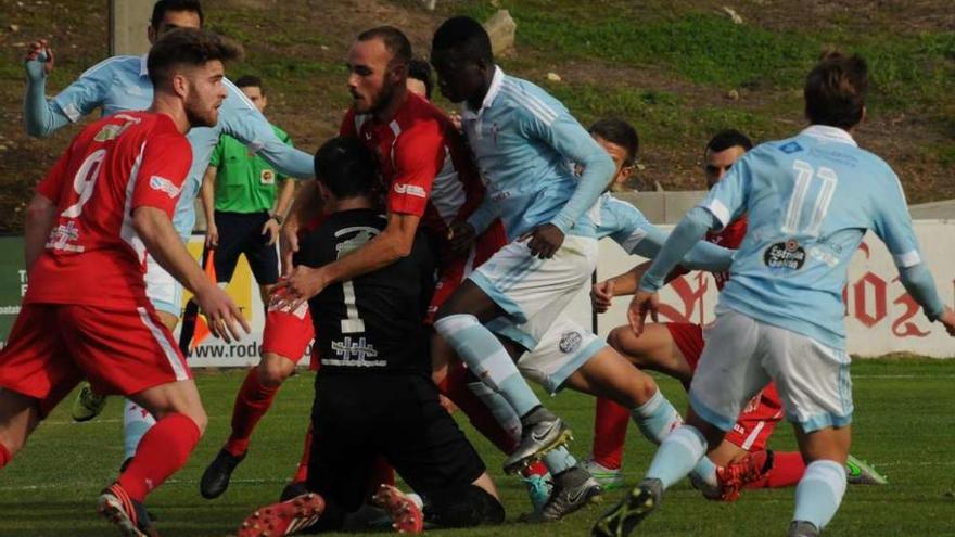 Manda, portero del Somozas, se hace con un balón protegido por un compañero ante el acoso de varios jugadores del Celta B. // Eugenio Álvarez