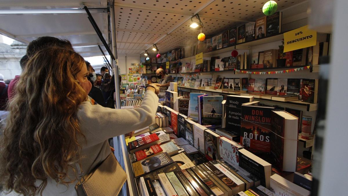 Una mujer compra en una caseta de la Feria del Libro de Mérida, en una edición pasada.