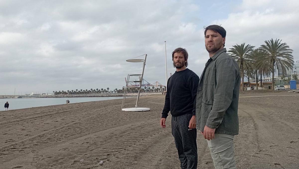 Los socorristas Emiliano Cortés y Pedro Fernández, hace unos días en La Malagueta, junto a una torre de vigilancia, este mes.