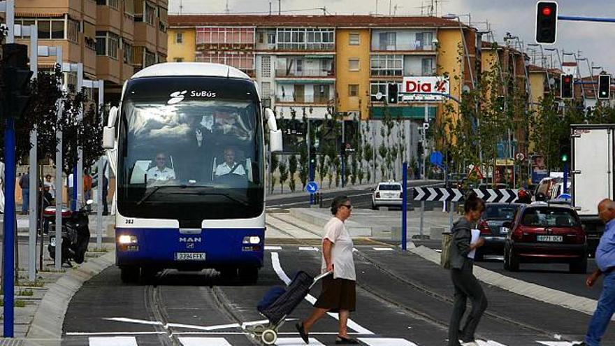 Un autobús urbano en pruebas espera que crucen los peatones en uno de los tramos compartidos con el tranvía, ayer