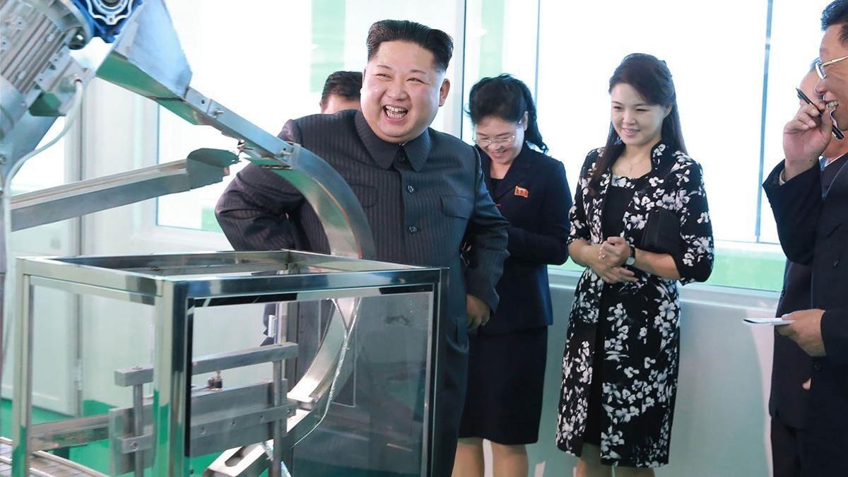 Kim Jong-un durante la visita a la fábrica, junto a su mujer, Ri Sol-ju (segunda por la derecha), en una foto difundida el domingo por la KCNA.