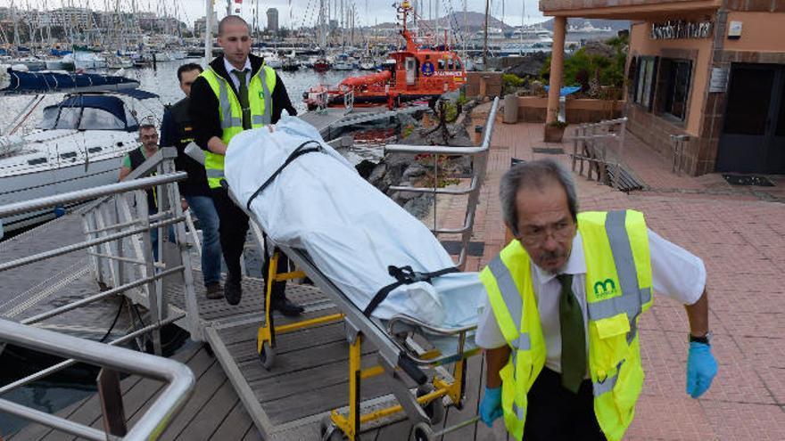 El traslado del cuerpo sin vida recuperado en la costa aruquense, ayer, en el Muelle Deportivo.