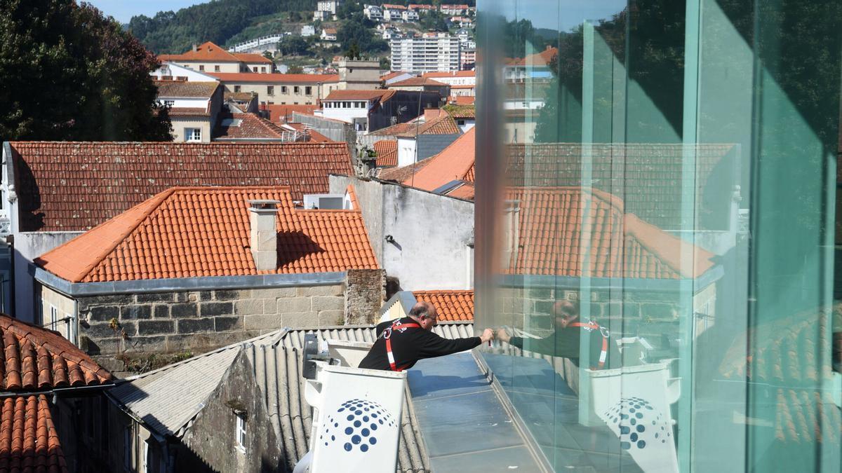 Un profesional limpia los cristales exteriores del Edificio Castelao.