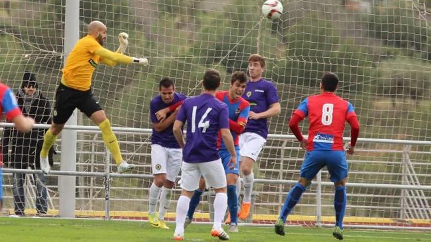 Despeje de puños de Chema en una de las últimas acciones del partido, ante el lateral Rafita y el canterano Benja.